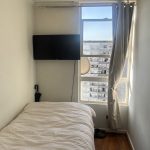 Dormitorio con colcha lisa color crudo